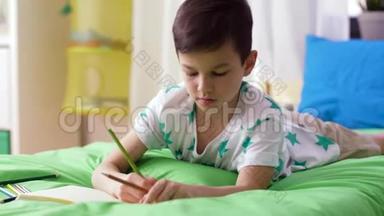 有笔记本和铅笔在家画画的男孩